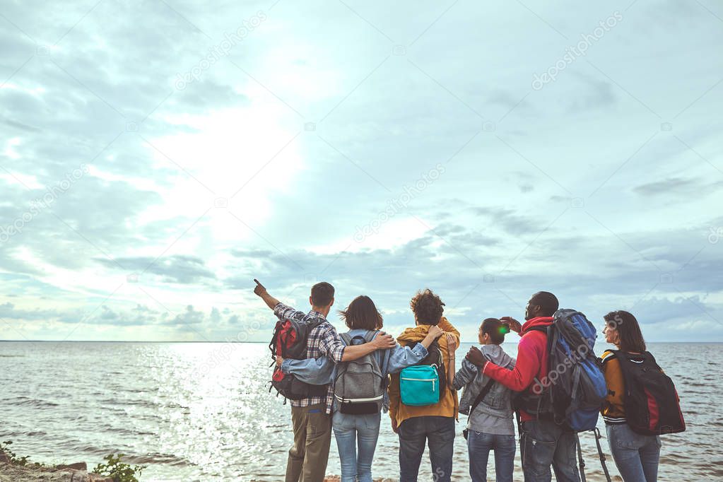 Group of folks looking at sun and the sea