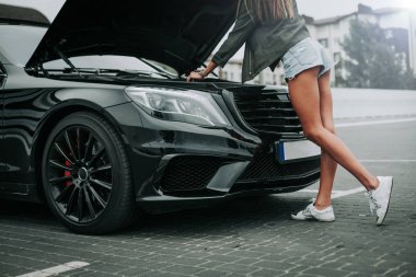 Kadın alarak motoru dışında açık hood karşısında bulma sırasında modern araç