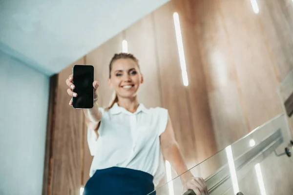 Pleased female employer showing display of mobile — Stock Photo, Image