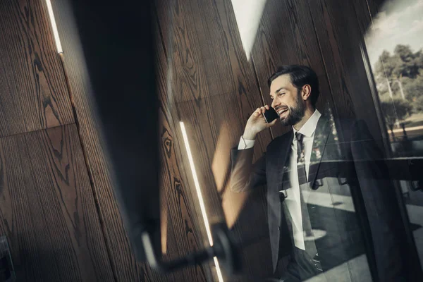 Sonriente barbudo macho diciendo en el teléfono interior — Foto de Stock