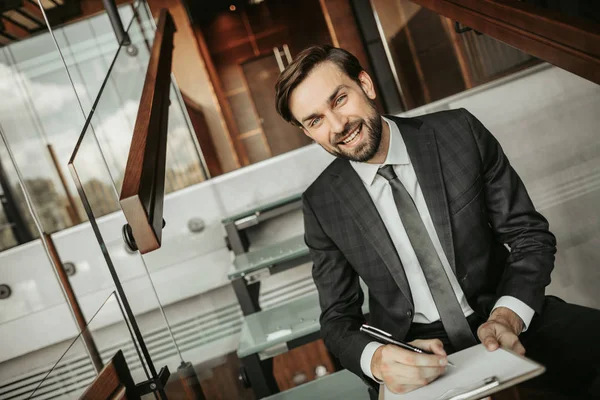 Feliz hombre de negocios sin afeitar haciendo notas durante el parto —  Fotos de Stock