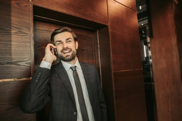 Positive unshaven male employer speaking on mobile — Stock Photo, Image