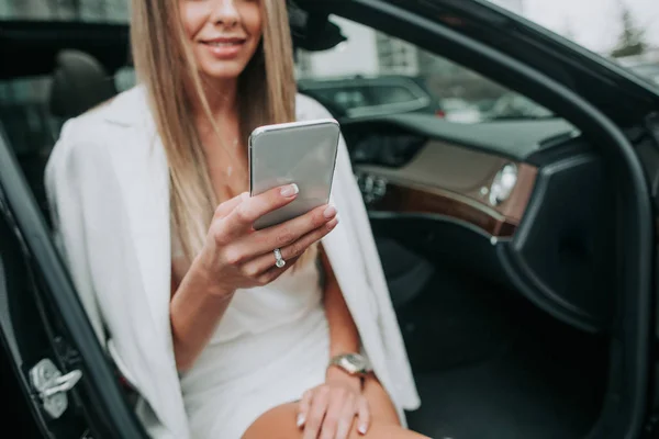 Mujer feliz escribiendo en el móvil en el coche — Foto de Stock