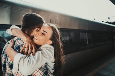 Kız sarılma adam tren istasyonu üzerinde gülümseyen