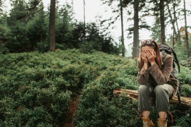 Genç Bayan Ağaç gövdesinde otururken elinde yüz gömme