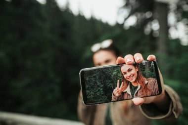 Genç Bayan Smartphone ile onun selfie ekranda holding