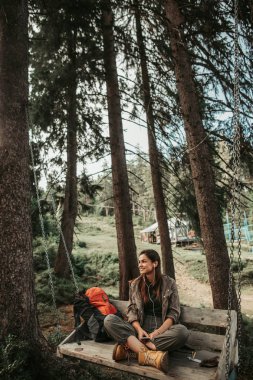 Ormandaki salıncak üzerinde oturan genç Sevimli bayan