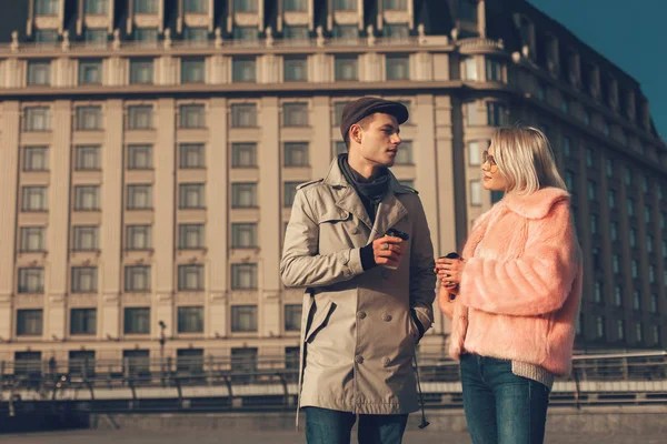Jovem casal segurando xícaras de café enquanto estava na rua — Fotografia de Stock