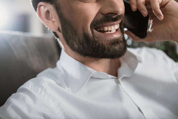 Grinning man is having fun during phone conversation — Stock Photo, Image