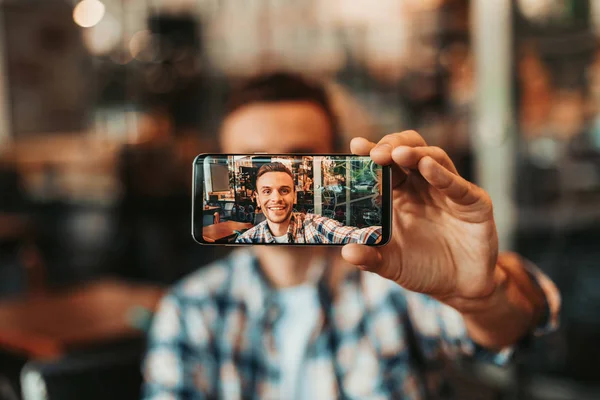 Gelukkig man doen foto op telefoon binnen — Stockfoto