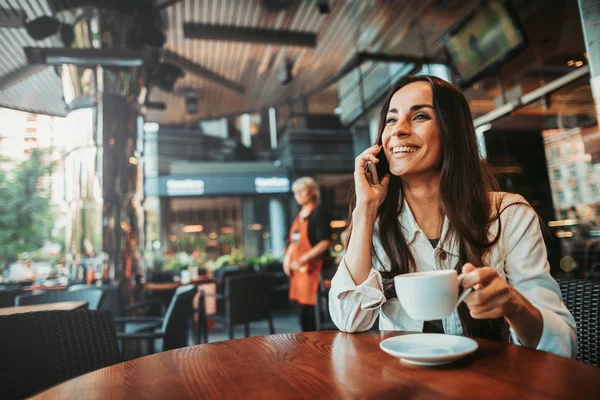 Позитивная женщина разговаривает по телефону во время отдыха — стоковое фото