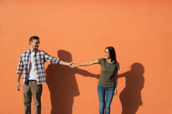 Menina alegre segurando braço de macho feliz — Fotografia de Stock