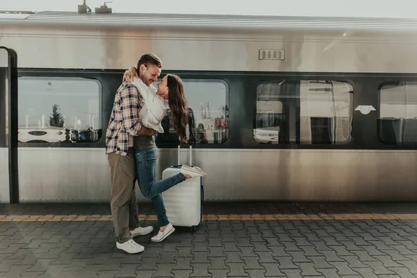 Веселая девушка обнимает весёлого мужчину на платформе — стоковое фото