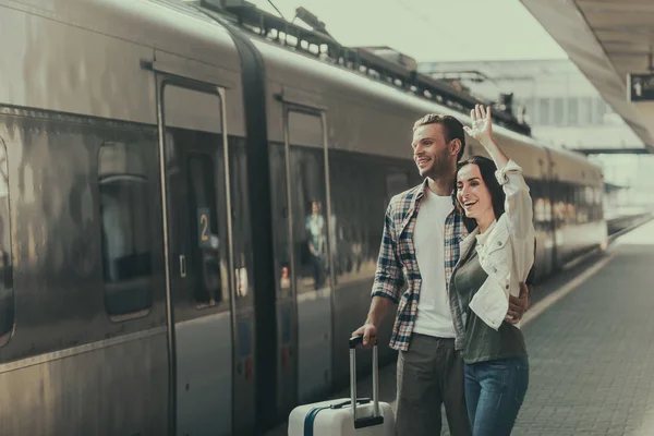 Positive male embracing outgoing girl on platform — Stock Photo, Image