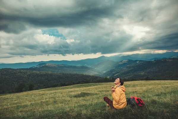 丘の上に座ってうれしそうなブルネットの女性 — ストック写真