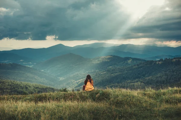 Панорамный снимок горного пейзажа с женщиной-путешественницей — стоковое фото