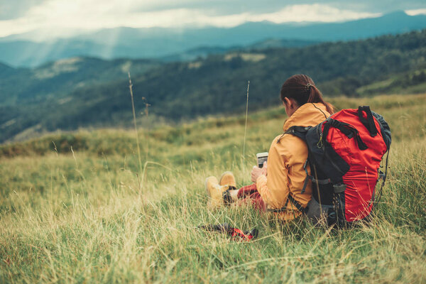 Pleasant relaxed woman sitting on the mountain hill