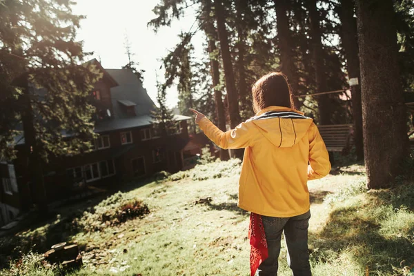 Девушка указывает на большой дом в лесу — стоковое фото