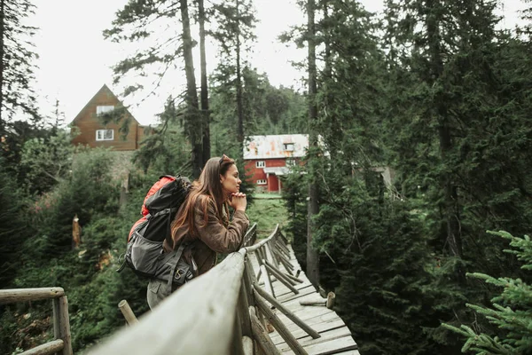 Attractive young lady leaning against wooden bridge — Stock Photo, Image