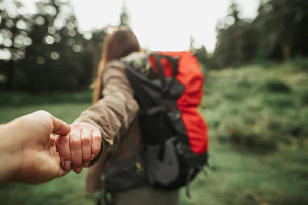 Young woman holding hand of her boyfriend while heading to the forest — Stock Photo, Image