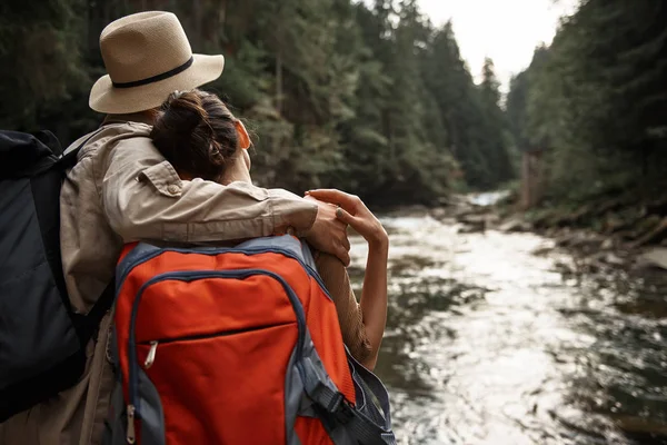 Ζευγάρι από ταξιδιώτες που αγκαλιάζει και να βλέπουν τα δέντρα και τη ροή του ποταμού — Φωτογραφία Αρχείου