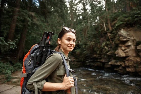 Peaceful traveler smiling and carrying her big backpack — Stock Photo, Image