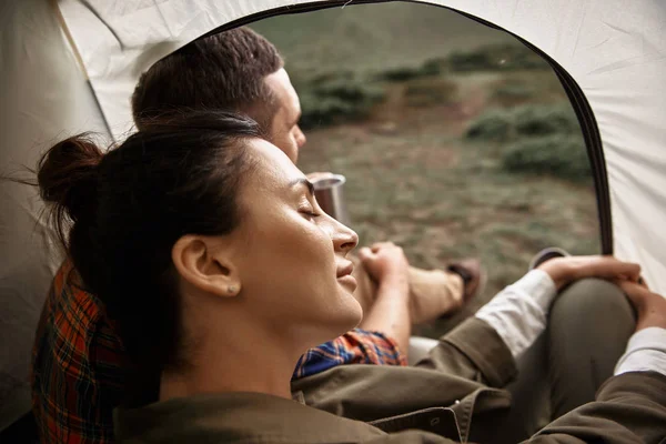 Lugn kvinna stänga hennes ögon medan du sitter i tältet med make — Stockfoto