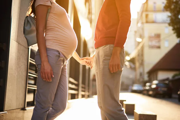 Zukünftige glückliche Eltern halten Händchen auf der Straße — Stockfoto