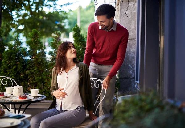 Caring bearded man pulling chair out for his beautiful wife — Stock Photo, Image