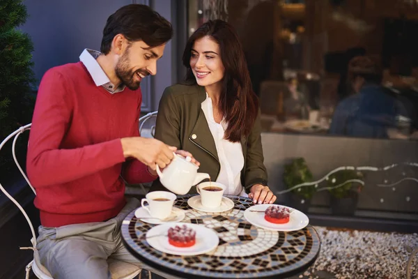 Joyful bearded man pouring tea for his charming girlfriend — Stock Photo, Image