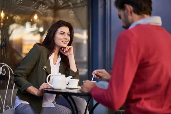 Beautiful young lady spending time with friend in outdoor cafe — Stock Photo, Image