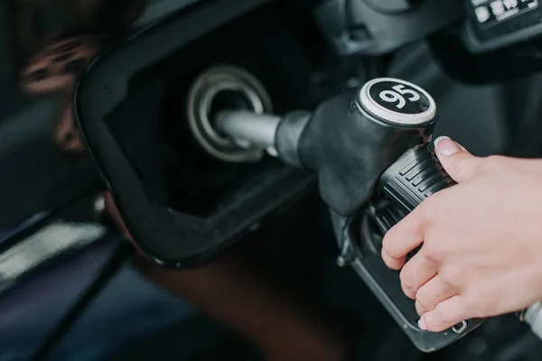 Senhora que derruba linha de gasolina na entrada de gasolina — Fotografia de Stock