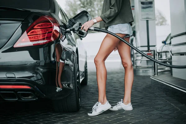 Bonita senhora reabastecendo o carro contemporâneo lá fora — Fotografia de Stock