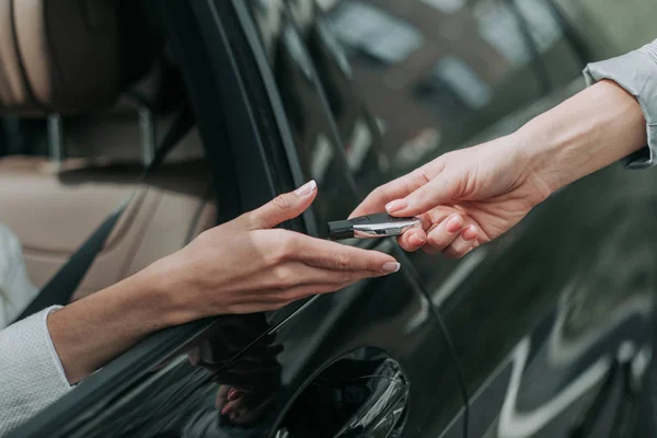 Mulher mão tomando chave do vendedor de automóveis — Fotografia de Stock