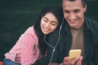Sevgilisi için eğilerek ve müzik gülümseyen kadın