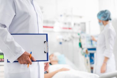 Pano ve hemşire soluk kontrol ederken kalem tutan doktor