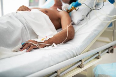 Ameliyattan sonra beyaz çarşaf altında hastanede yatan adam