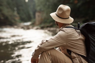 Büyük şapka ve su akışı arayan adam