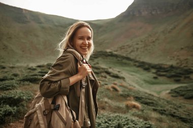Mutlu kadın dağlarda seyahat ederken gülüyor