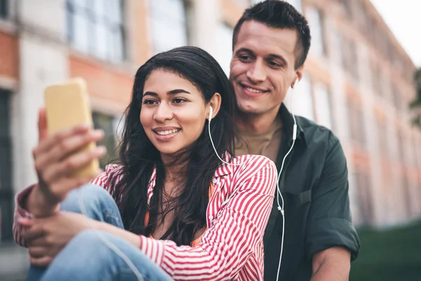 Milující pár poslouchá hudbu a při pohledu na obrazovku — Stock fotografie