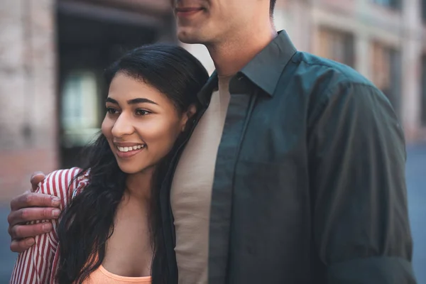 Nahaufnahme einer jungen Frau, die lächelt, während ein fröhlicher Mann sie umarmt — Stockfoto