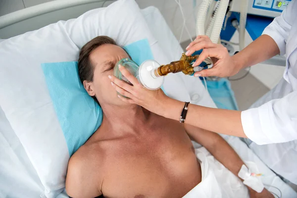 医者の腕眠っている患者に入れて酸素マスク — ストック写真