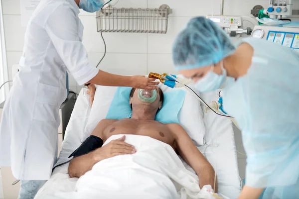 集中治療病棟に患者を置く酸素マスクを医師します。 — ストック写真