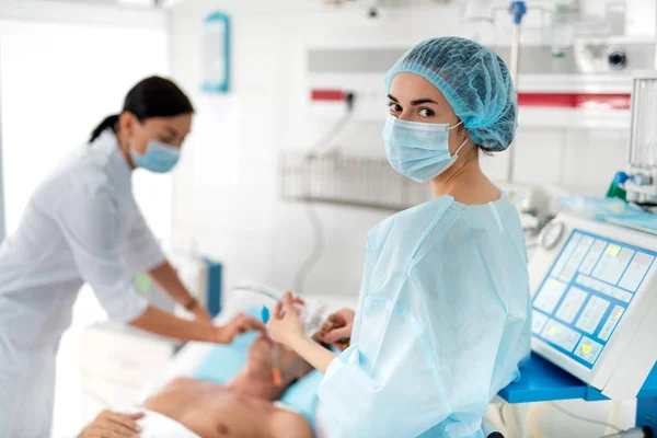 Медсестра в стерильній формі, що тримає респіраторне обладнання — стокове фото
