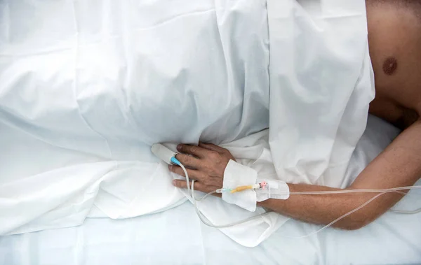 白いシーツの下で病院のベッドに横たわっている患者 — ストック写真