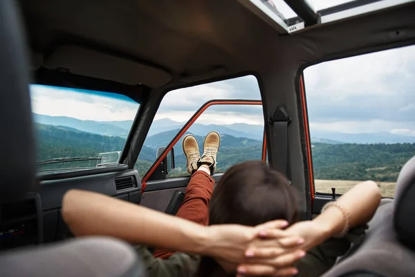 Entspannte junge Frau liegt im Auto — Stockfoto