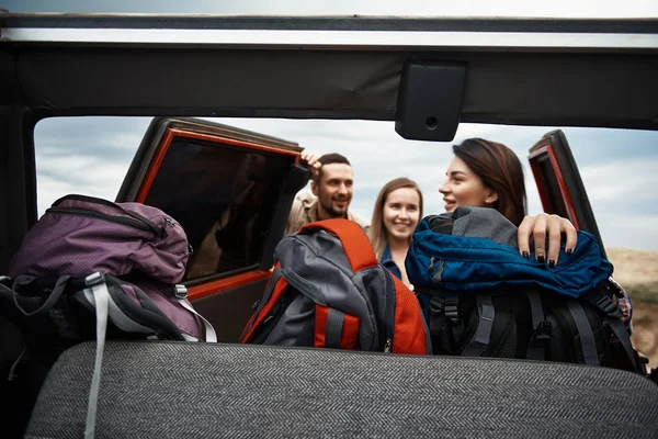 Viajantes jovens positivos recebendo suas mochilas do carro — Fotografia de Stock