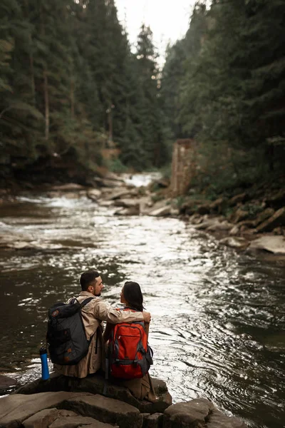 Romantische wandelaar zijn vriendin kijken terwijl haar knuffelen in de buurt van de rivier — Stockfoto