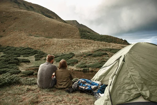 Horizontal photo of two hikers sitting near their tent — Stock Photo, Image