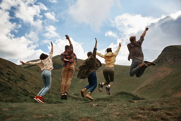 Teljes hosszúságú, izgatott emberek Ugrás a hegyekben — Stock Fotó